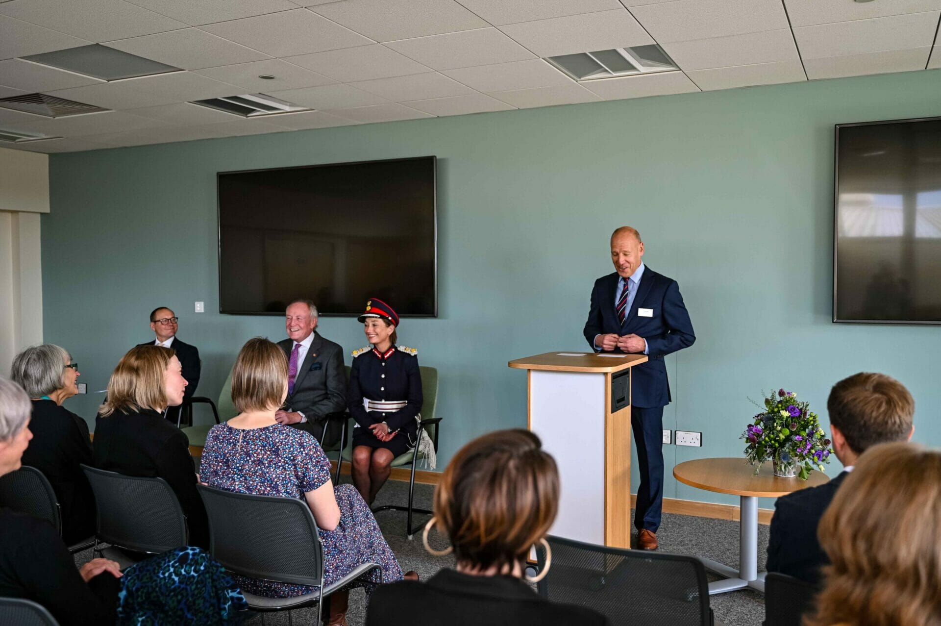 A man giving a speech at a lectern in group offices