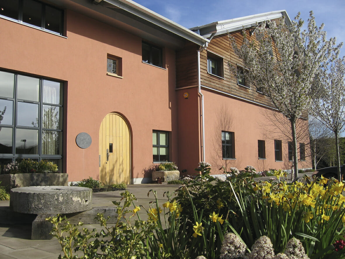 The exterior shot of a bakery with spring flowers planted outside the entrance way