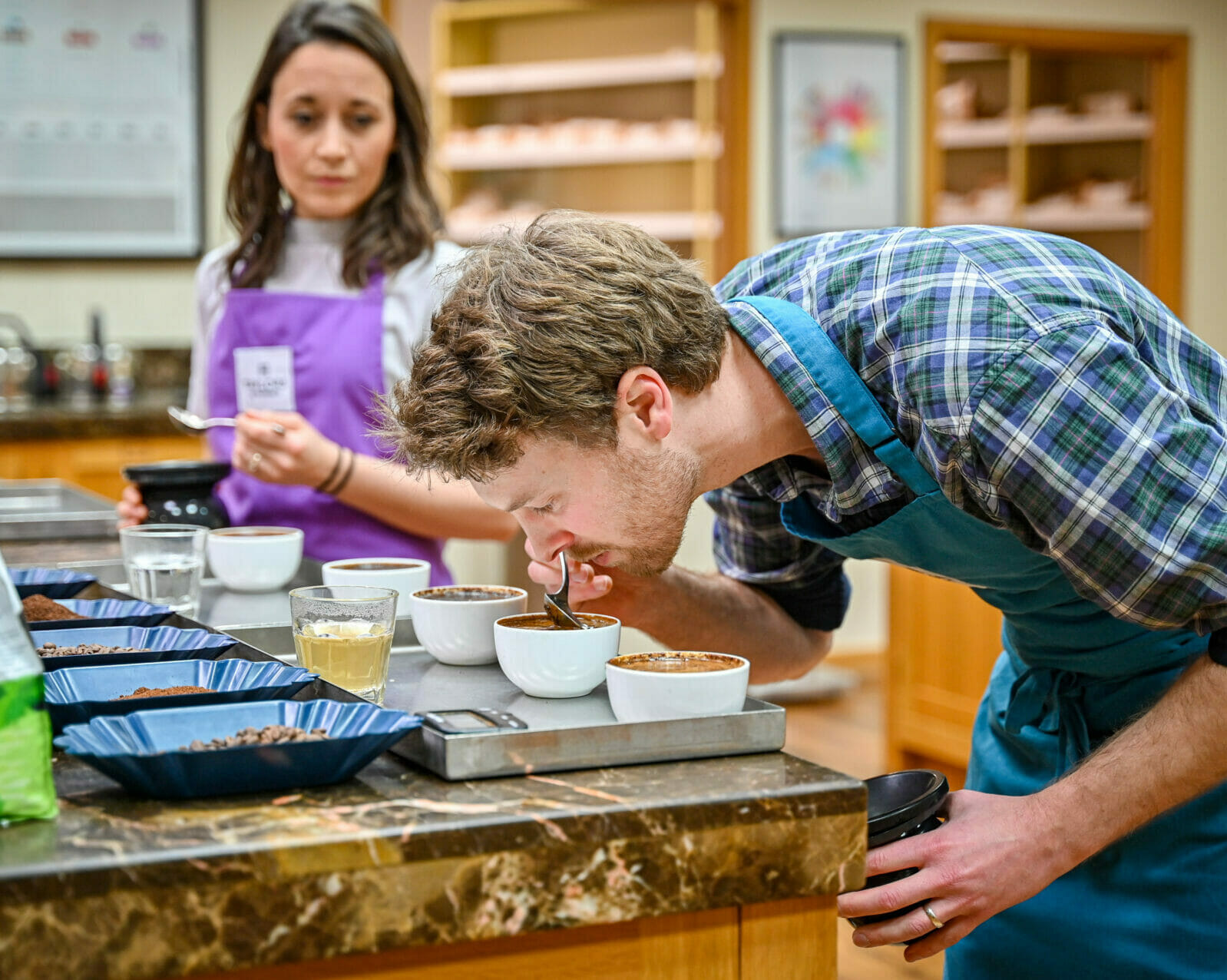 A man testing and tasting coffee with a spoon