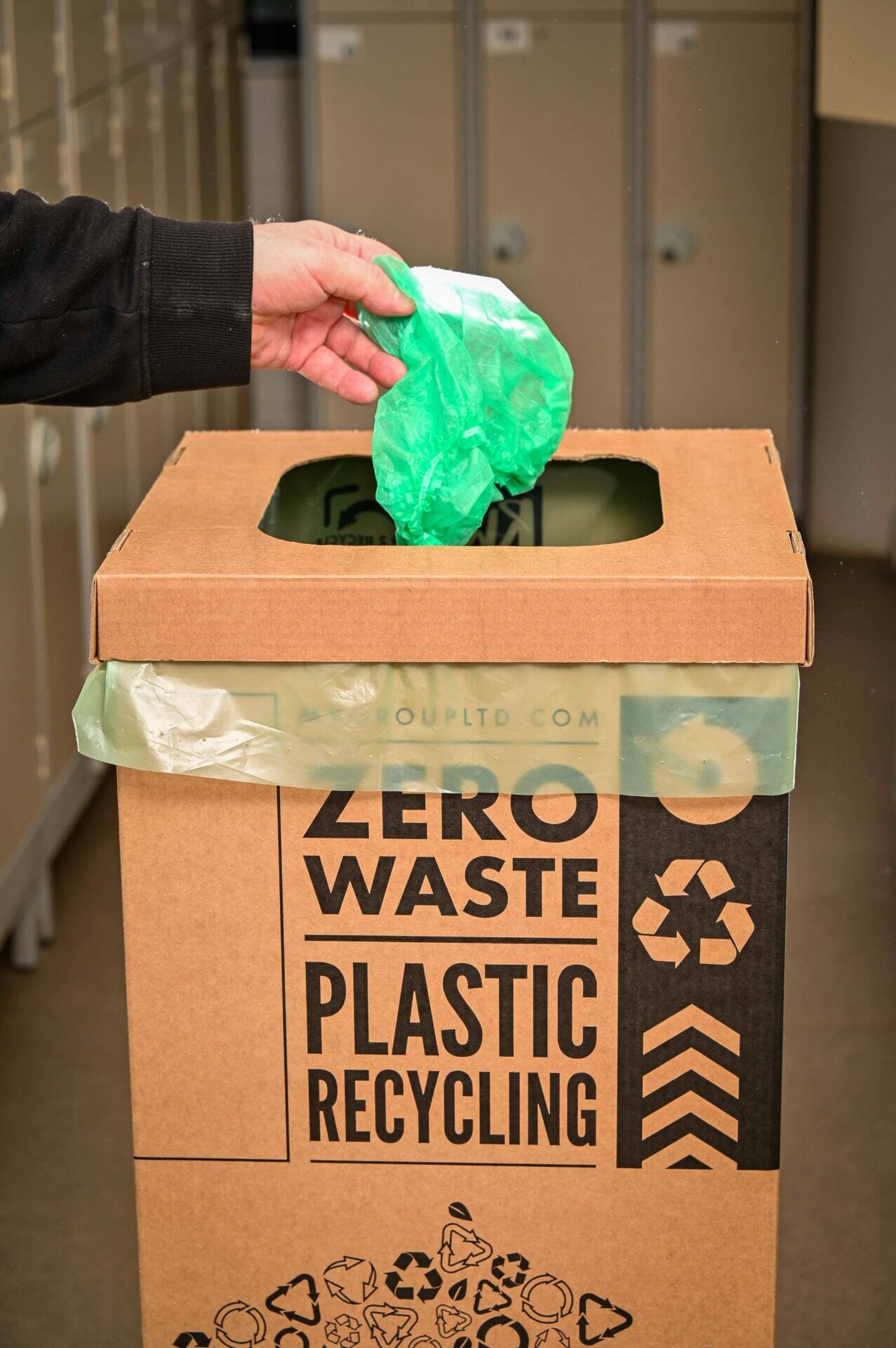 A man recycling his hair net in the appropriate bin