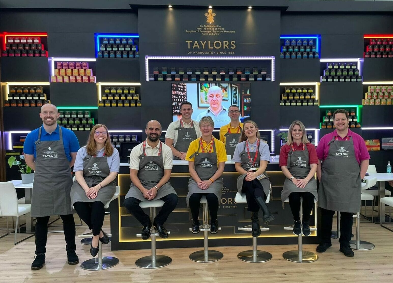 A photo of a group of people in front of an exhibition stand displaying different teas.