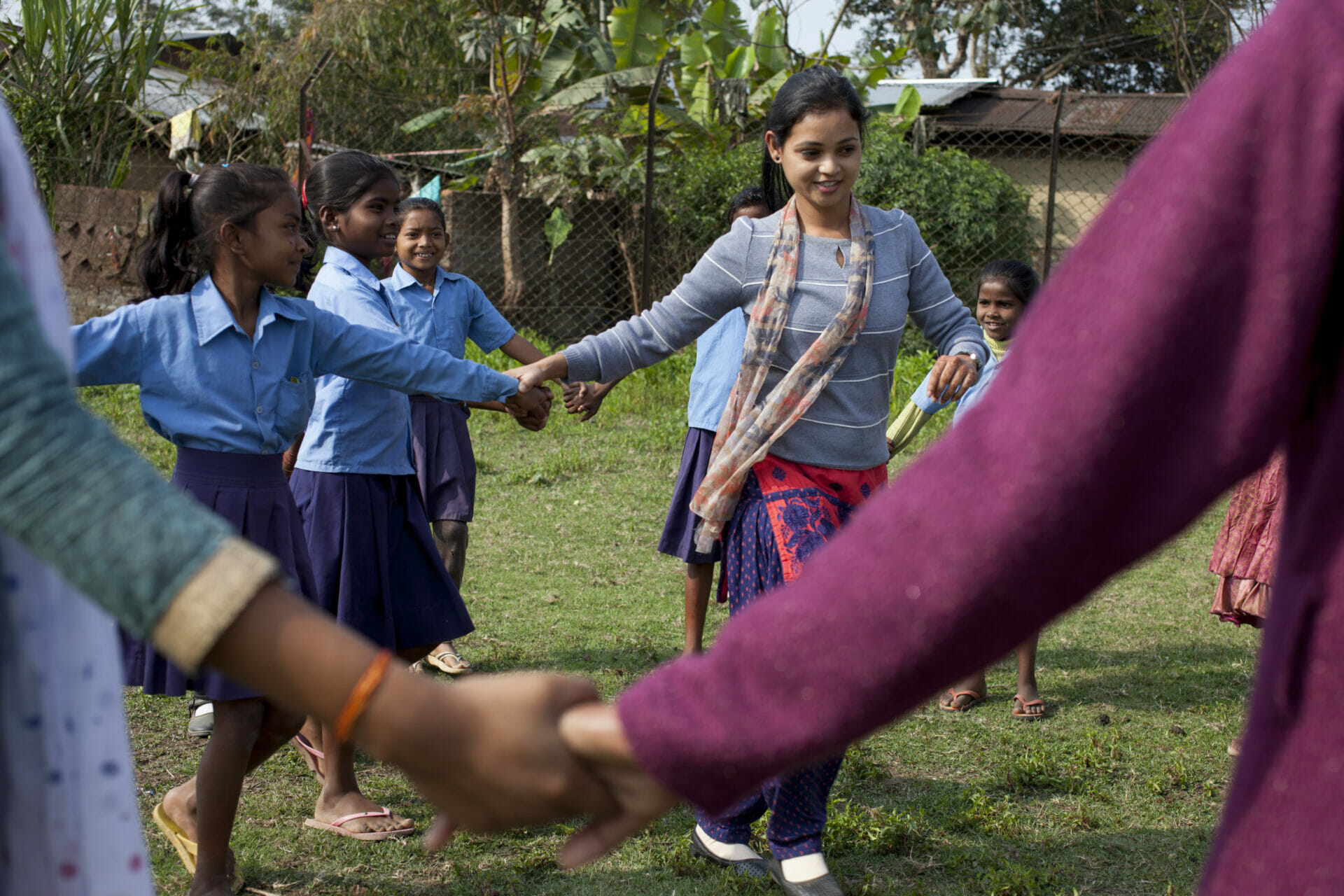 A group of girls and young women holding hands.