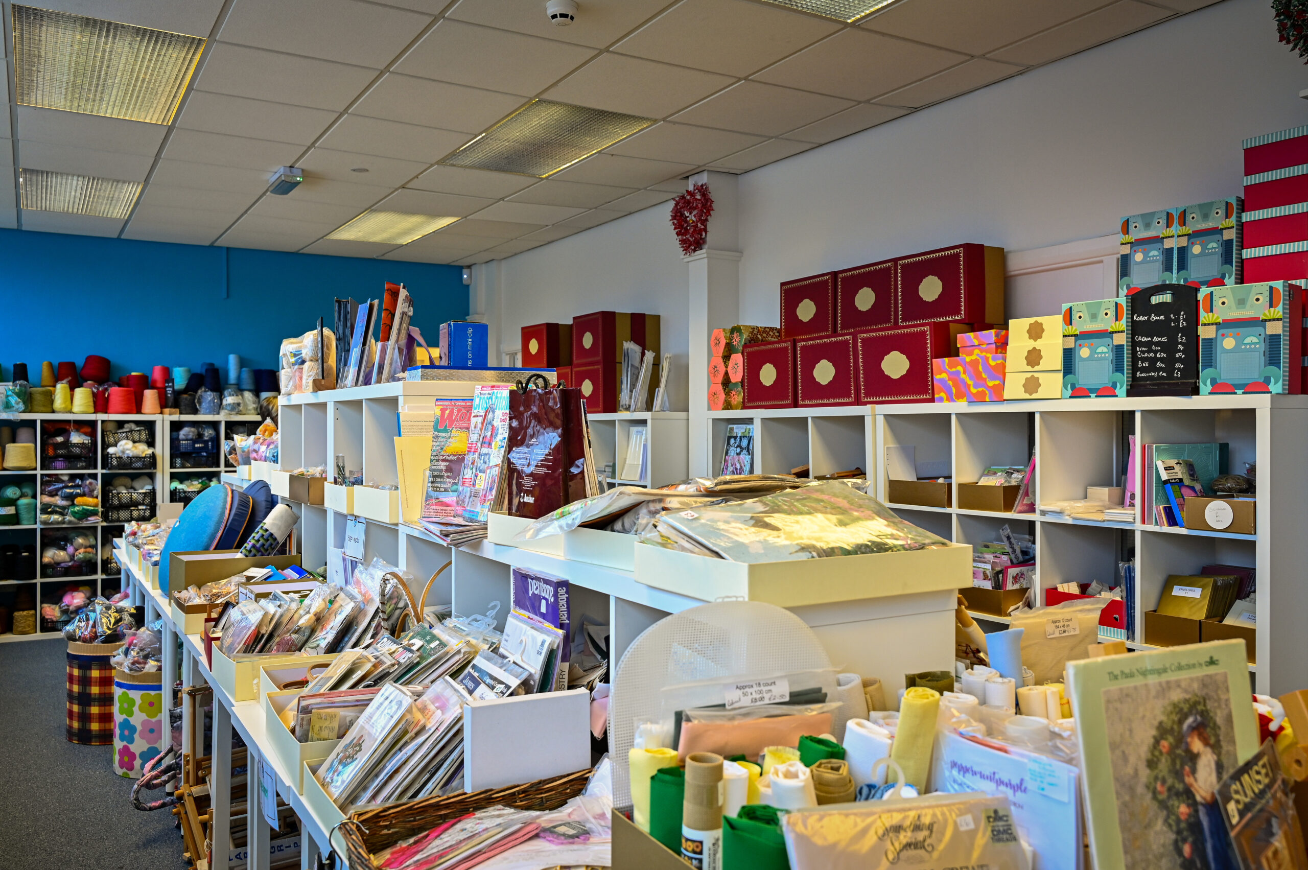The interior of a craft and haberdashery shop showing spools of ribbon, thread and remnant fabrics.