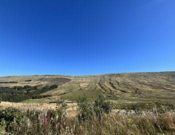 A landscape shot of the Snaizeholme valley against a brilliant blue sky.